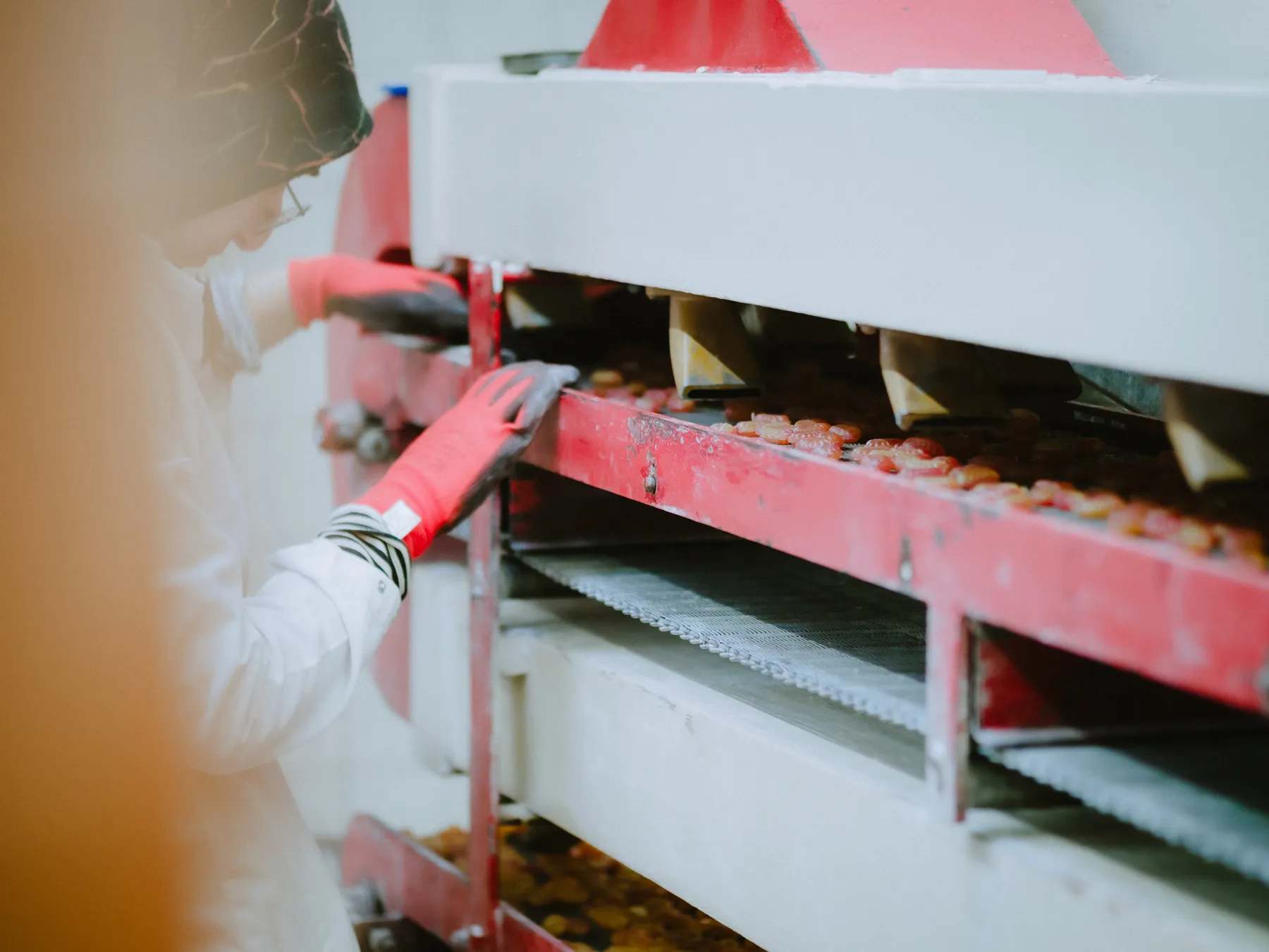 Mitarbeiter bei der Verpackung an den Produktionsregalen in der Bonbonmanufaktur